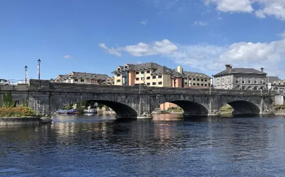 Stone bridge and colorful buildings along the river in Galway’s Latin Quarter, a charming stop for senior travelers in Ireland