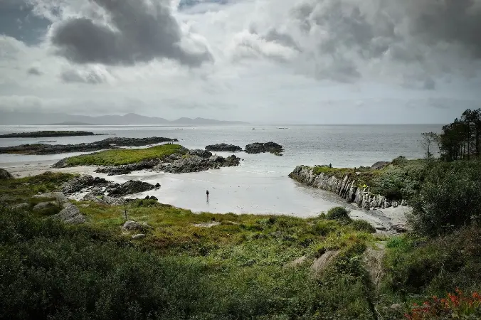 Dramatic coastal view along the Ring of Kerry, Ireland, with rocky shores and calm waters, perfect for scenic senior travel