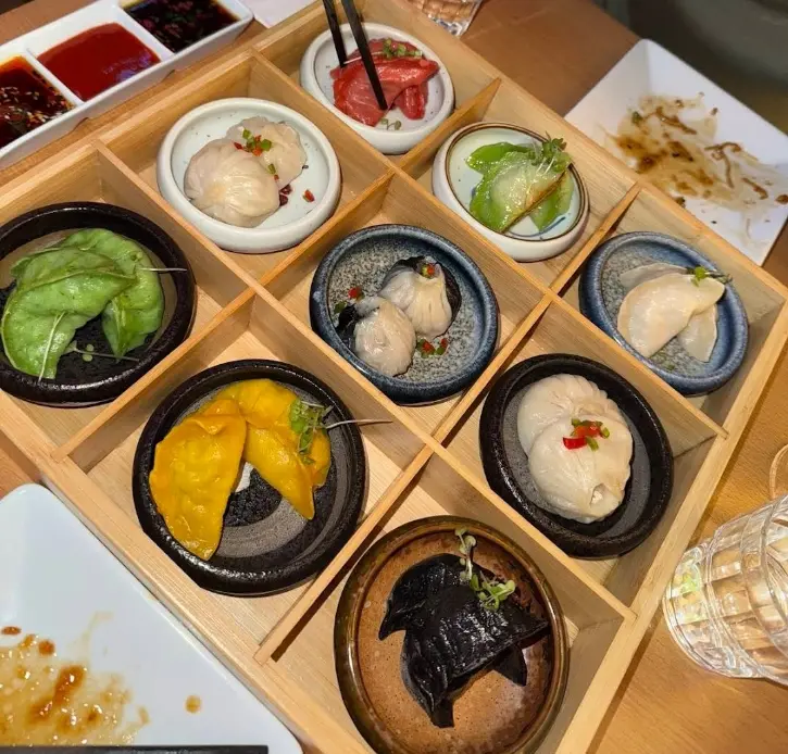 Assorted steamed and pan-fried dumplings in a bamboo basket and on a plate at CN Dumpling, Dublin