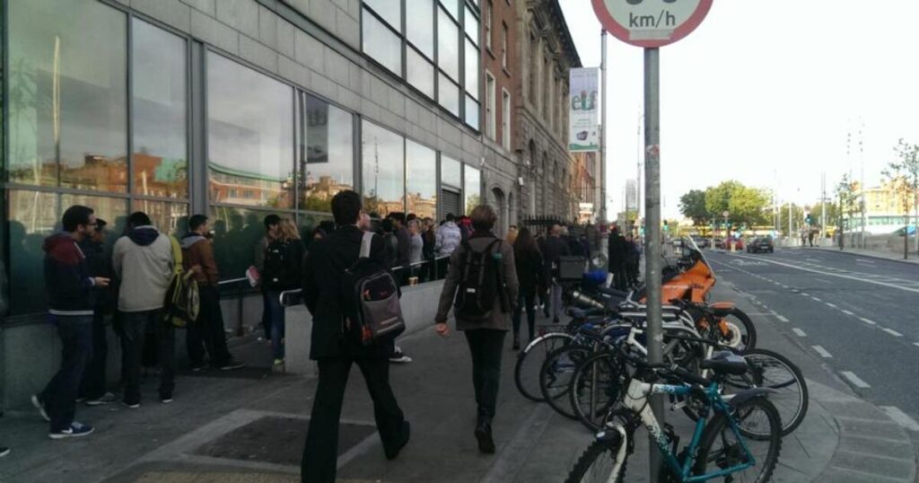 people waiting in line outside immigration office Dublin Burgh Quay building